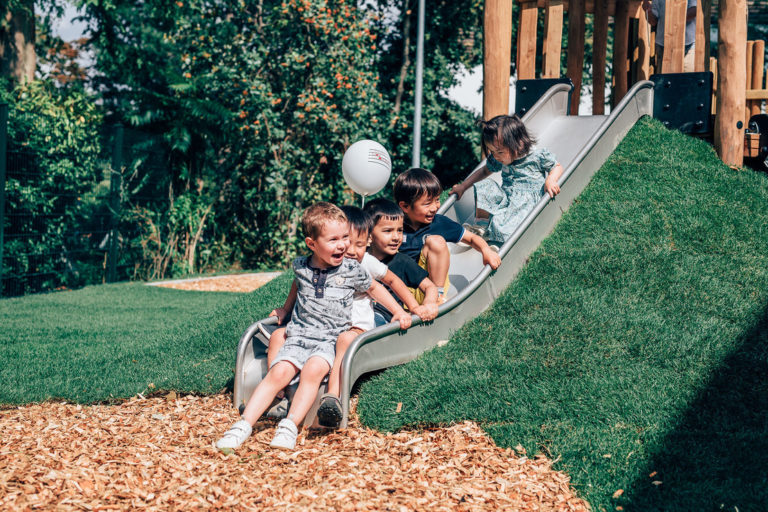 Children on the slide in the outdoor area of ISR Kindergarten Düsseldorf
