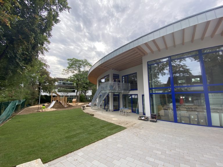The modern building of ISR Kindergarten Düsseldorf in Niederkassel with its outdoor play area